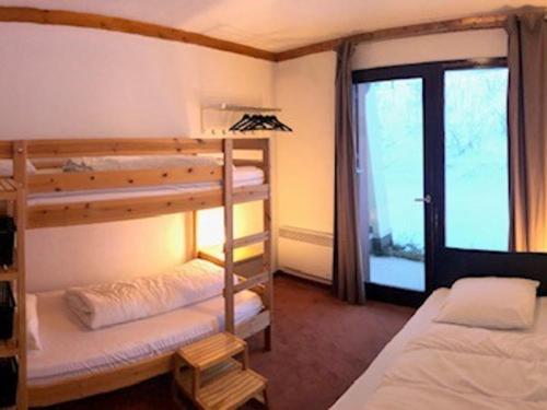 une chambre avec deux lits superposés et une fenêtre dans l'établissement Appartement cosy 6/8 pers, Valfréjus, près pistes et télécabines - FR-1-265-343, à Modane