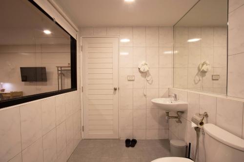 a white bathroom with a sink and a toilet at Gate78 Hostel Maephim Beach in Mae Pim