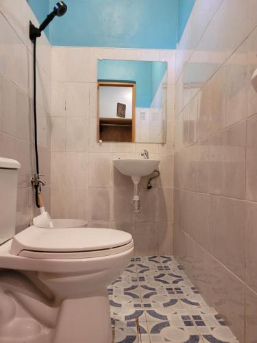 ein Bad mit einem WC und einem Waschbecken in der Unterkunft Cecilia's Guest House in Siquijor