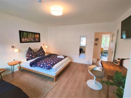 ein Schlafzimmer mit einem Bett und einem Schreibtisch in einem Zimmer in der Unterkunft Zwei Zimmer Wohnung Nähe Bahnhof in Karlsruhe