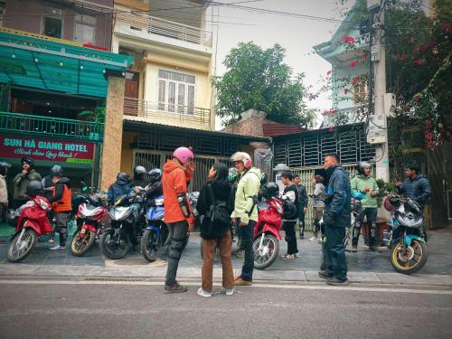 a group of people standing on a street with motorcycles at Sun Hà Giang Hotel-tours-motorbike rental in Ha Giang