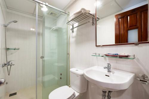 een badkamer met een toilet, een wastafel en een douche bij Hoang Hoang Hotel (Bloom 3) in Ho Chi Minh-stad