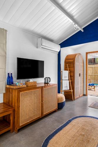 a living room with a flat screen tv on a wall at Azora by Ayatana, Goa in Morjim