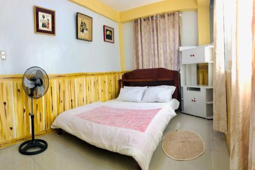 a bedroom with a large bed and a fan at Baguio Exotic Vacation House in Baguio