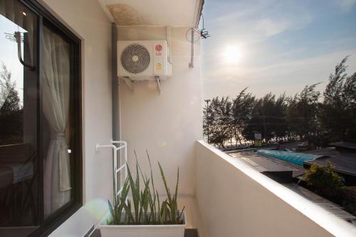 d'un balcon avec un ventilateur et des plantes à la fenêtre. dans l'établissement Gate78 Hostel Maephim Beach, à Mae Pim