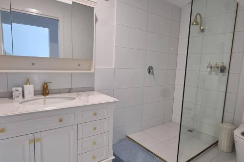 a white bathroom with a shower and a sink at Serenity View Studio Retreat in Woombye