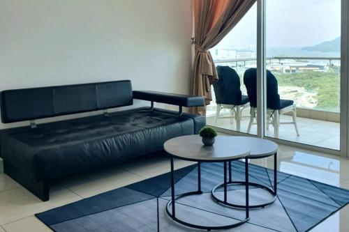 sala de estar con sofá negro y mesa en Southbay Seaview Condo A16 #10minQueensbay #15minSPICE, en Bayan Lepas