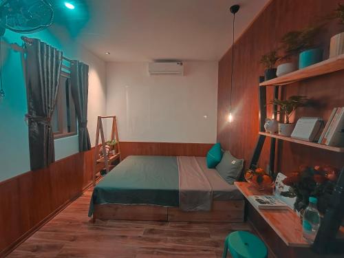 a small bedroom with a bed and a desk at Banana homestay( Chuối Homestay) in Hue