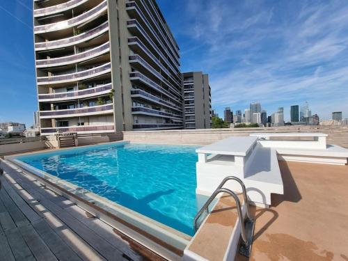 une piscine sur le toit d'un immeuble dans l'établissement Comfortion Le Papillon - Appartement de luxe avec vue et piscine, à Puteaux