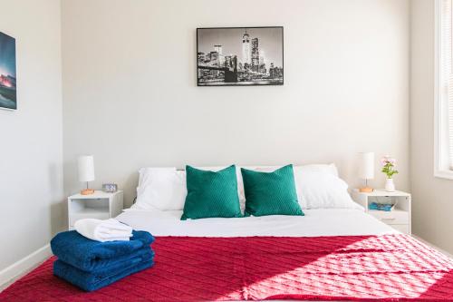 a white bedroom with a bed with a red rug at Spacious, Relaxing & Gorgeous 4BD/4BA House in DC! in Washington, D.C.