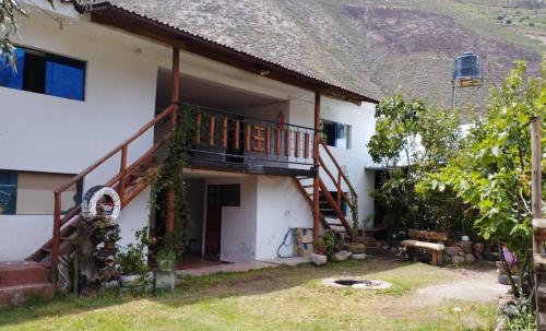 a house with a balcony and a staircase at Casa Corazao in Urubamba