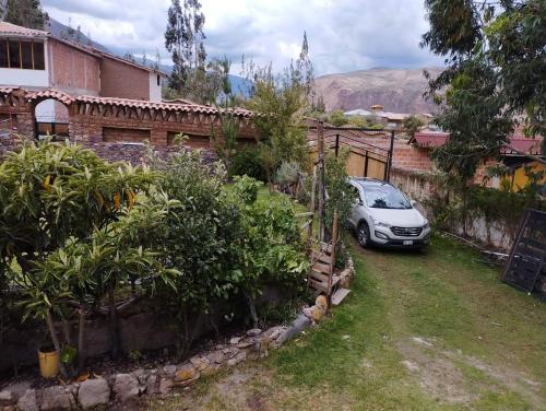 un coche aparcado en el patio de una casa en Casa Corazao, en Urubamba