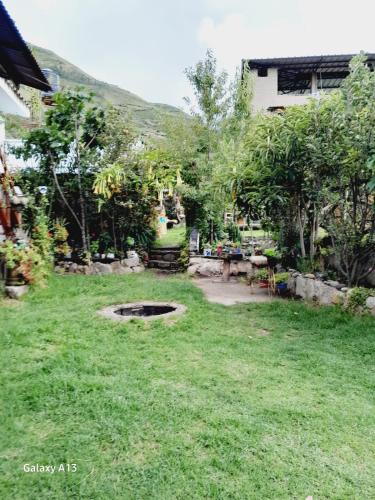 a yard with a pond in the grass at Casa Corazao in Urubamba