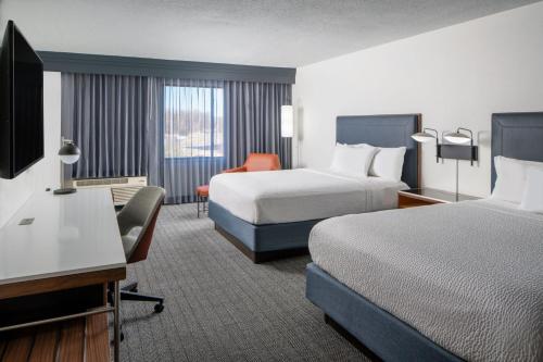 a hotel room with two beds and a desk at Courtyard by Marriott Decatur in Decatur