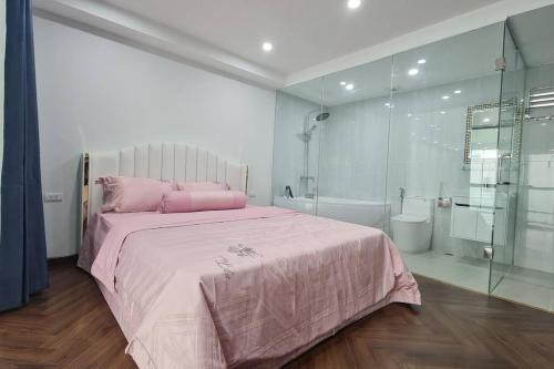 ein Schlafzimmer mit einem rosa Bett und einer Dusche in der Unterkunft Penthouse Cao Cấp Tại Hà Nội in Hanoi