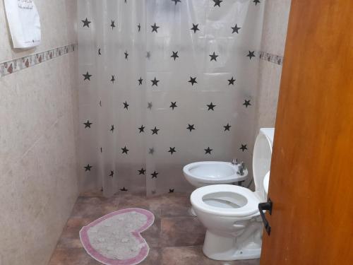 uma casa de banho com WC e estrelas negras na parede em Dpto del Sur em San Roque