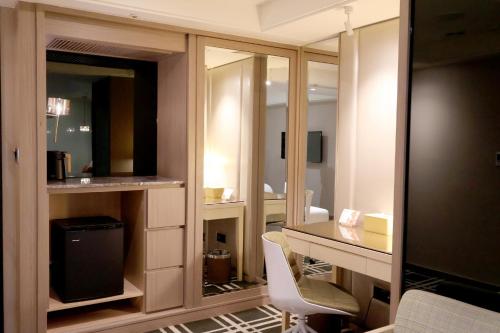 a bathroom with a desk and mirrors in a room at Olah Poshtel Taichung Wenxin in Taichung