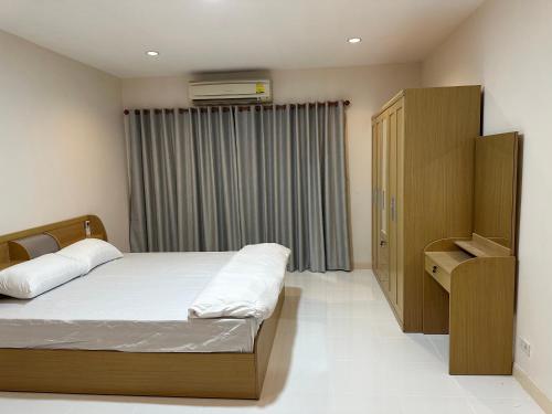 um pequeno quarto com uma cama e uma janela em Country Complex Bangna em Bangkok