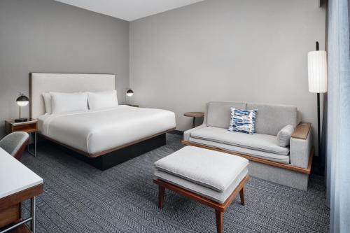 una camera d'albergo con letto e divano di Courtyard Baton Rouge Siegen Lane a Baton Rouge