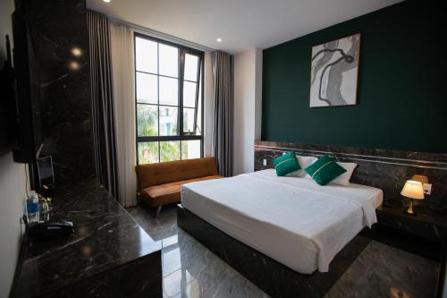 a hotel room with a bed and a couch at Riverside 1 Hotel in Can Tho