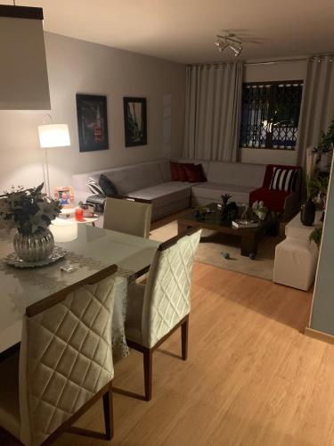 a living room with a couch and a table and chairs at Quarto área central zona 04 in Maringá