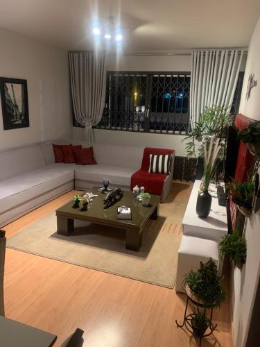 a living room with a couch and a coffee table at Quarto área central zona 04 in Maringá