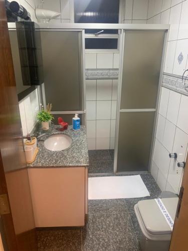 La salle de bains est pourvue d'une douche, d'un lavabo et de toilettes. dans l'établissement Quarto área central zona 04, à Maringá