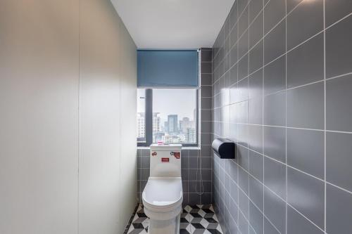 uma casa de banho com um WC e uma janela em Yootel Hostel em Hangzhou