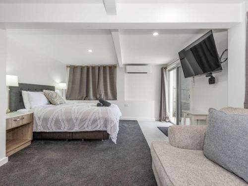 a bedroom with a bed and a flat screen tv at Sutherland Sunrise in Kingscliff