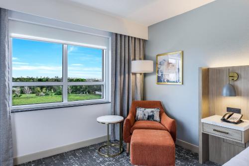 a hotel room with a chair and a window at Crowne Plaza Ft Myers Gulf Coast by IHG in Fort Myers