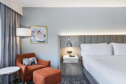 a hotel room with a bed and a chair at Crowne Plaza Ft Myers Gulf Coast by IHG in Fort Myers
