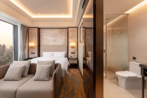 um quarto de hotel com uma cama e um chuveiro em Grand New Century Hotel Binjiang Hangzhou em Hangzhou