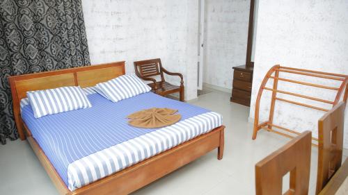 a bedroom with a bed with a blue and white striped mattress at Hillstreet Villa in Dehiwala
