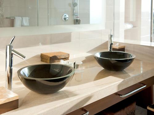 a bathroom with two black sinks on a wooden counter at Shima Kanko Hotel The Bay Suites in Shima
