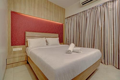 1 dormitorio con 1 cama grande y cabecero rojo en JAI MALHAR RESIDENCY, en Kālundri