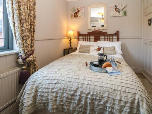 a bedroom with a bed with a tray of food on it at The Old Clock Makers in Ashbourne