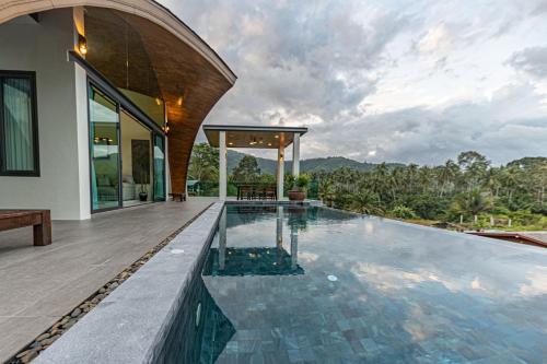 een overloopzwembad in een villa met een huis bij ขนอม คิริณณ์ Khanom Kirin Private Pool Villa in Ban Plau