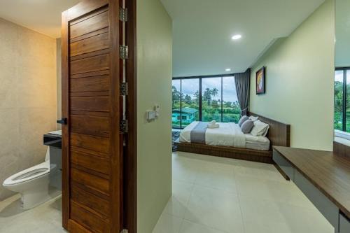 een slaapkamer met een bed en een toilet in een kamer bij ขนอม คิริณณ์ Khanom Kirin Private Pool Villa in Ban Plau