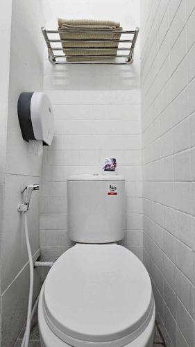 a bathroom with a white toilet with a roll of toilet paper at W District Guesthouse in Bangkok