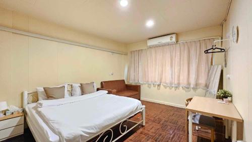 a hospital room with a bed and a window at W District Guesthouse in Bangkok