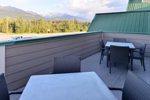 a patio with tables and chairs with mountains in the background at Canadas Best Value Inn Valemount in Valemount