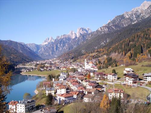 a small town on a hill next to a lake at Casetta next to the Creek Dino Buzzati in Belluno