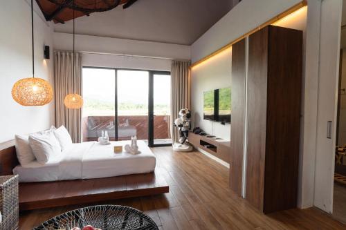 a bedroom with a bed and a living room at Nacpan Beach Resort Managed by H Hospitality Group in El Nido