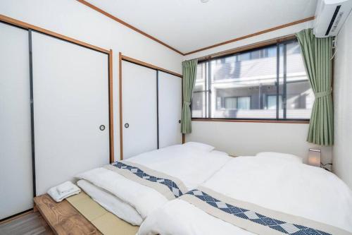 a bedroom with two beds and a window at 匯家風花ビル in Tokyo