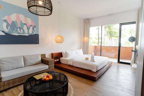 a living room with a bed and a couch at Nacpan Beach Resort Managed by H Hospitality Group in El Nido