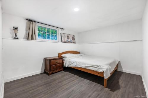 a small bedroom with a bed and a window at Deluxe Basement with Private Bedroom - R1 / R3 in Vancouver