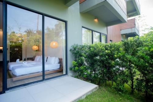a bedroom with a bed outside of a window at Nacpan Beach Resort Managed by H Hospitality Group in El Nido