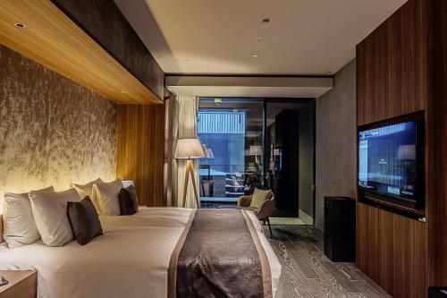 a hotel room with a bed and a flat screen tv at MUWA NISEKO in Kutchan