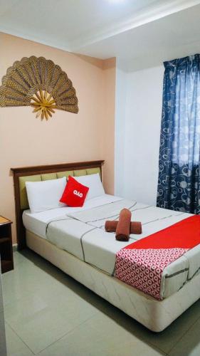 a bedroom with a large bed with red and white pillows at Hotel Casa Reo in Kampong Bagan Lalang