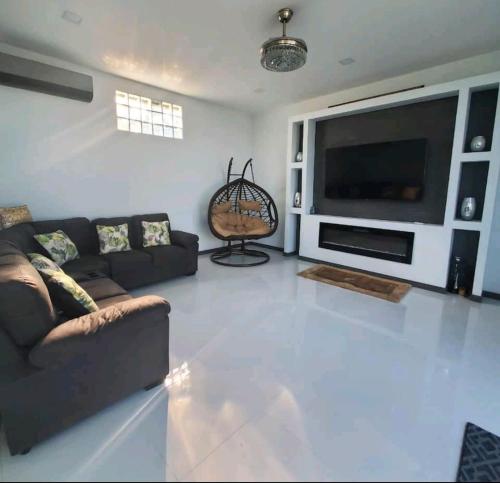 a living room with a couch and a large television at marhabibi home in Sonsonate